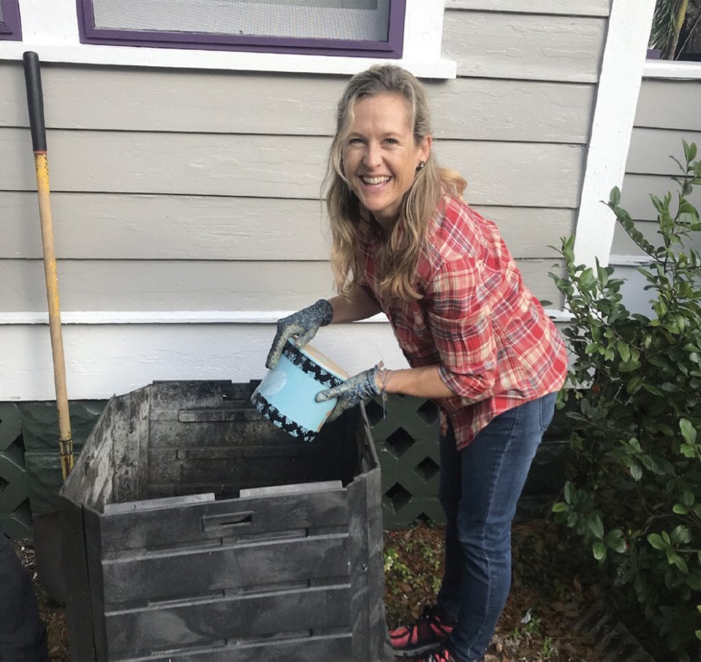 Lindsay Cross, environmental scientist, pours her compost into her newly reconstructed community compost bin with the help of MakeSoil.