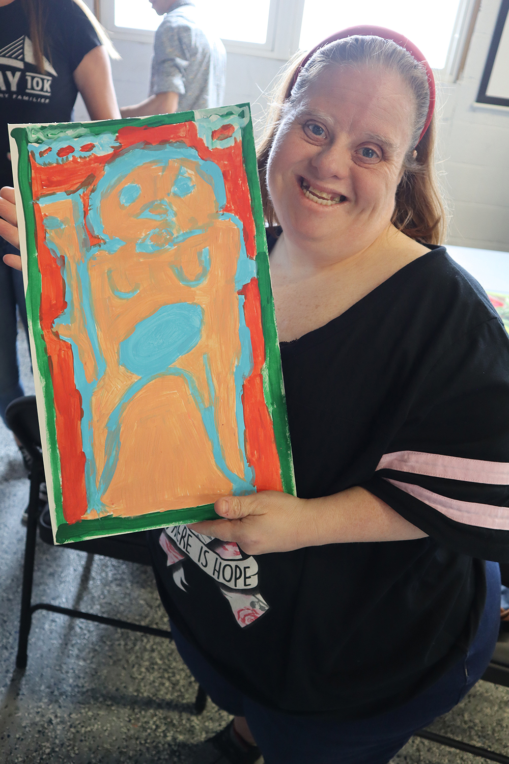 Artist Stacey with her painting, “Bigfoot”. Photo by Marilyn Malara.